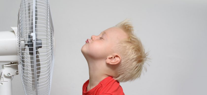 Boy Staying Cool in Front of Fan